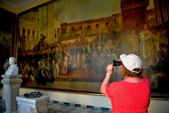 -Un touriste prend une photo d'un tableau du peintre français Jean Baptiste Vermay à El Templete à La Havane, le 12 avril 2019. Vermay (1786-1833) dépeint les événements historiques cubains et révolutionne les arts à Cuba. Ses peintures sont un must pour les touristes et les artistes qui visitent la XIIIe Biennale d'art contemporain de La Havane. Photo de YAMIL LAGE / AFP / Getty Images.