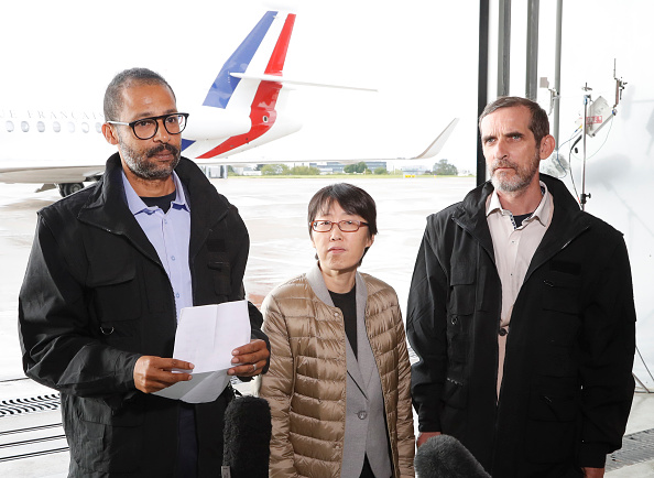 -Les otages français libérés Patrick Picque et Laurent Lassimouillas se tiennent à côté d'un otage sud-coréen qui n'a pas encore été identifié, alors qu'ils parlent à la presse à leur arrivée à l'aéroport de Villacoublay, près de Paris, le 11 mai, 2019. L'armée française a libéré quatre otages deux français, un américain et un sud-coréen lors d'une intervention dans le nord du Burkina Faso au cours de laquelle deux soldats français ont été tués, a annoncé la présidence française le 10 mai 2019. Photo par FRANCOIS GUILLOT / AFP / Getty Images.