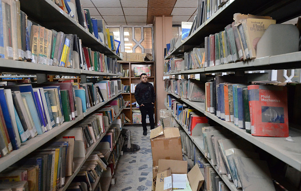 -Un homme se tient parmi des livres poussiéreux dans la nouvelle bibliothèque de l'Université de Mossoul dans la ville au nord de l'Irak le 17 avril 2019. Pendant des siècles, Mossoul était connue pour ses artistes et ses écrivains, pour ses bibliothèques regorgeant de livres en plusieurs langues. Le groupe État islamique a brûlé de précieuses archives. Photo de Zaid AL-OBEIDI / AFP / Getty Images.