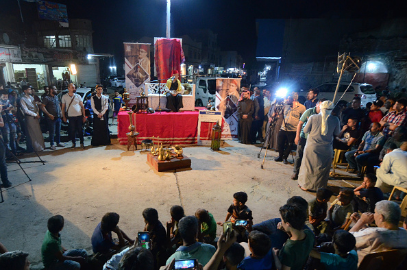 -Le conteur traditionnel Abdel Wahed Ismail (sur scène) anime un public à Mossoul, une ville du nord de l'Irak, pendant le mois sacré du Ramadan, le 17 mai 2019. En Irak, comme dans d'autres pays musulmans, le mois de l'aube Le jeûne jusqu'au crépuscule est un moment propice aux réunions du soir dans les restaurants, les cafés ou les domiciles de parents et d'amis irakiens. Photo de Zaid AL-OBEIDI / AFP / Getty Images.