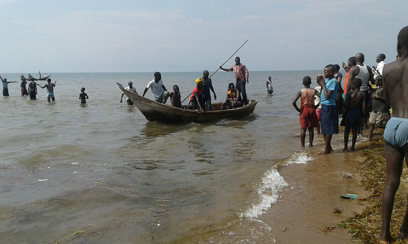 -Illustration-Des sauveteurs sont vus sur un bateau de pêche sur le lac Albert, huit personnes ont été noyées et 15 autres sont portées disparues, elles allaient à un match foot. Photo crédit should read /AFP/Getty Images.