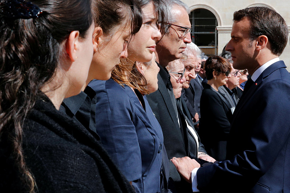 Emmanuel Macron salue les familles de Cédric de Pierrepont et Alain Bertoncello le 14 mai pendant l’hommage national rendu aux deux héros dans la cour de l’Hôtel des Invalides. Crédit : PHILIPPE WOJAZER/AFP/Getty Images.