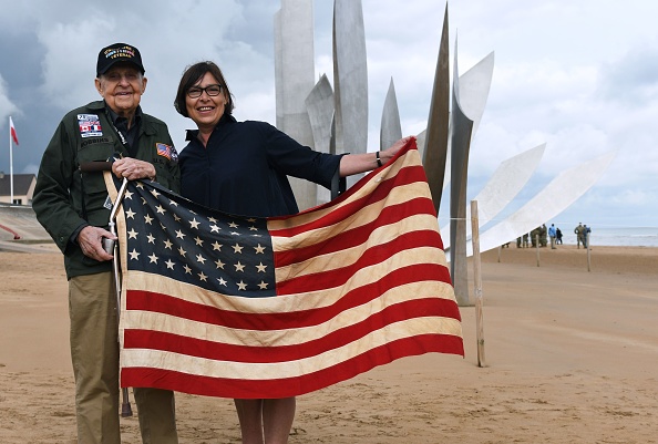 K.T. Robbins prend la pose avec une touriste le 5 juin 2019 sur la plage d’Omaha Beach. Crédit : FRED TANNEAU/AFP/Getty Images.