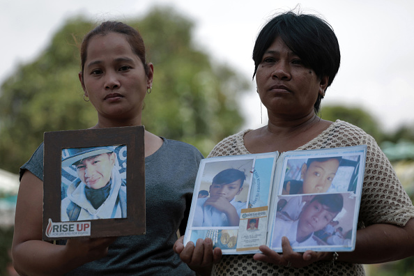 -Katherine Bautista 37 ans et Emily Soriano, 49 ans, anciennes partisanes de la guerre de la drogue du président philippin Rodrigo Duterte, tiennent des photos de leurs fils qui auraient été tués lors d'opérations policières. Depuis lors, la police affirme avoir tué 4 854 usagers de drogue présumés ou revendeurs en légitime défense, alors que les groupes de défense des droits estiment que le bilan est au moins le triple. Photo de Jake C Salvador / AFP / Getty Images.