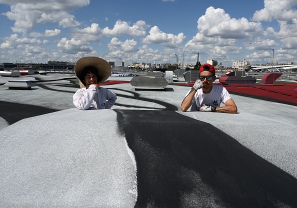 -Les artistes français Ella et Pitr posent sur le toit de Paris du parc des Expositions le 6 juin 2019 à Paris, Porte de Versailles, alors qu'ils travaillent sur le plus grand tableau mural d'Europe, qui aura la taille de quatre terrains de football. Photo de Dominique FAGET / AFP / Getty Images.