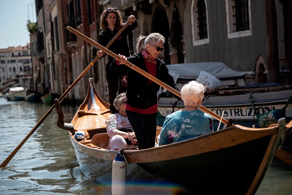 -Des femmes passionnées et experte "vogatrici" donnent une leçon aux touristes le 16 mai 2019 à Venise. Row Venice est une organisation à but non lucratif vouée à la préservation de la "culture acquise" vénitienne et au centre de celle-ci. Photo de MARCO BERTORELLO / AFP / Getty Images.