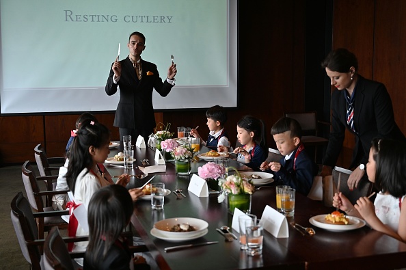 Cette photo prise le 1er juin 2019 montre Guillaume de Bernadac enseignant aux enfants comment utiliser les couverts pendant un cours sur l'étiquette et les bonnes manières dans le centre de Shanghai. Photo HECTOR RETAMAL / AFP / Getty Images.