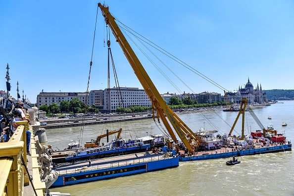 -Une photo prise le 11 juin 2019 montre la grue flottante géante sur le navire Clark Adam soulevant le bateau de tourisme coulé pendant les opérations de retrait du Danube à Budapest. Un bateau de tourisme transportant principalement des touristes sud-coréens a coulé le 29 mai. Photo de GERGELY BESENYEI / AFP / Getty Images.