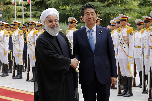 -Le président iranien Hassan Rouhani serre la main du Premier ministre japonais Shinzo Abe lors d'une cérémonie de bienvenue au palais de Saadabad, dans la capitale, Téhéran, le 12 juin 2019. Photo by - / AFP / Getty Images.