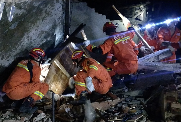 -Les secouristes recherchent les survivants du tremblement de terre dans les décombres d'un bâtiment à Yibin, dans la province du Sichuan au début de la journée du 18 juin 2019. Photo de STR / AFP / Getty Images.