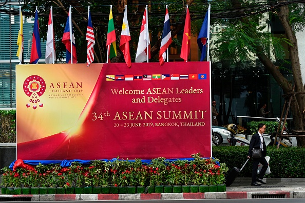 -Un homme passe devant un panneau publicitaire près du lieu du 34ème sommet de l'Association des nations de l'Asie du Sud-Est à Bangkok, le 22 juin 2019. Photo de Romeo GACAD / AFP / Getty Images.