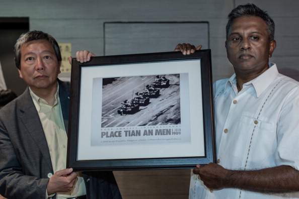 -Le secrétaire général d'Amnesty International, Salil Shetty, offre une copie de la photo de Tank Man de Jeff Widener à Lee Cheuk-yan. Photo PHILIPPE LOPEZ / AFP / Getty Images.