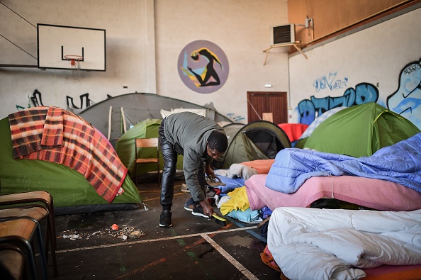 Un immigrant au milieu des tentes et des matelas qui jonchent le sol du gymnase de l’ancien lycée Jeanne-Bernard, à Saint-Herblain, en banlieue nantaise. Crédit : LOIC VENANCE/AFP/Getty Images.