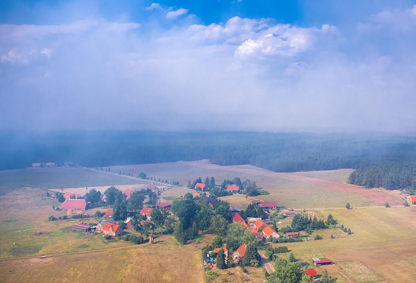 -Une photo prise le 1er juillet 2019 montre de la fumée au-dessus du petit village de Hohen Woos, à la limite de l'ancienne zone d'entraînement militaire, lors d'un grand incendie de forêt près de Luebtheen. Photo de JENS BUTTNER / AFP / Getty Images.