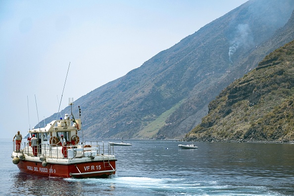 -Un bateau du Vigili del Fuoco, le Corps national italien des pompiers, patrouille au large de la ville portuaire de Ginostra le 4 juillet 2019, un jour après l'éruption du volcan Stromboli, sur l'île de Stromboli, au nord de la Sicile. Le volcan sur l'île italienne de Stromboli est entré en éruption dramatique le 3 juillet, tuant un randonneur et renvoyant les touristes à la mer. Photo de Giovanni ISOLINO / AFP / Getty Images.