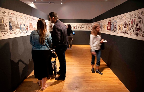 -Des membres du public regardent des extraits complets d'une tapisserie représentant la série télévisée à succès Game of Thrones au musée Ulster de Belfast le 5 juillet 2019. À l'instar de la tapisserie de Bayeux, la tapisserie Game of Thrones est tissée à la main brodé, avec des bordures décoratives et un récit pictural central. Il atteindra 90m d’ici la fin de la dernière saison du spectacle. Photo de Paul Faith / AFP / Getty Images.