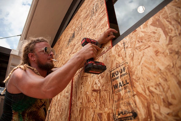 -Matt Harrington monte une protection dans un magasin de chaussures Vans près du quartier français de la Nouvelle-Orléans alors que la tempête tropicale Barry s'approche le 11 juillet 2019. Photo de Seth HERALD / AFP / Getty Images.