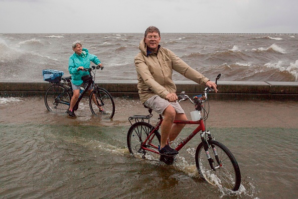 -Un couple circule à vélo au bord du lac Ponchartrain après que la tempête tropicale Barry a traversée Mandeville, en Louisiane, le 14 juillet 2019. Barry est le premier ouragan de la saison de l'Atlantique, il a été déclassé en tempête tropicale après avoir touché terre samedi. Photo de Joseph Prezioso / AFP / Getty Images.