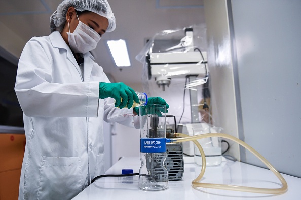 -Cette photo prise le 28 juin 2019 montre un technicien de laboratoire versant du sérum d'escargot dans un filtre purificateur à l'Institut thaïlandais de recherche scientifique et technologique de Bangkok. Le précieux mucus des mollusques, riche en collagène, pour certaines entreprises de cosmétiques, ils ont désormais plus de valeur que l'or. Photo par Lillian SUWANRUMPHA / AFP/ Getty Images.