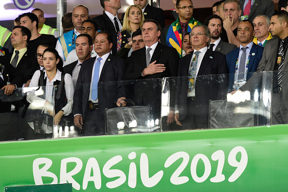 -Le Président du Brésil, Jair Bolsonaro, Paulo Guedes, ministre de l'Économie du Brésil et Cafu observent l'hymne national des tribunes précédant le match de la demi-finale de la Coupe América Brésil 2019 entre le Brésil et l'Argentine au Stade Mineirao le 02 juillet 2019 au Brésil. Photo par Juliana Flister / Getty Images.