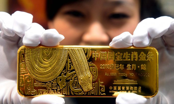 Une femme montre un lingot d'or marquant l'année du serpent, à Pékin, en 2012. (STR/AFP/Getty Images)