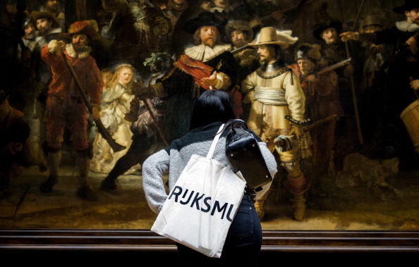 -Un visiteur regarde de plus près le tableau "la ronde de nuit " de Rembrandt, après une vaste rénovation de 375 millions d’euros (480 millions de dollars) sur 10 ans, visant à redonner vie à sa collection inégalée de chefs-d’œuvre du siècle passé. Photo Koen van Weel / AFP / Getty Images.