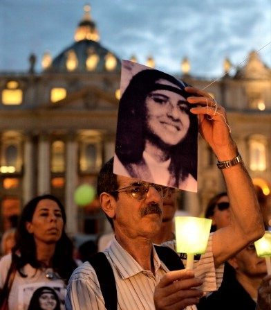 -Un manifestant tient une chandelle à l'occasion de la commémoration du 30e anniversaire de la disparition d'Emanuela Orlandi sur la place Saint-Pierre au Vatican, le 22 juin 2013. Emanuela Orlandi, 15 ans, fille d'un messager du Vatican vivait avec sa famille au Vatican, elle a disparu le 22 juin 1983 après un un cours de musique. Photo FILIPPO MONTEFORTE / AFP / Getty Images.