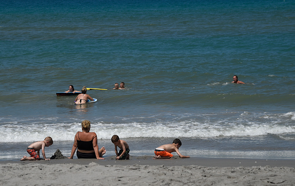 Image d'illustration : une famille s'amuse à la plage à Hope Sound Beach le 5 juillet 2016 (RHONA WISE/AFP/Getty Images)