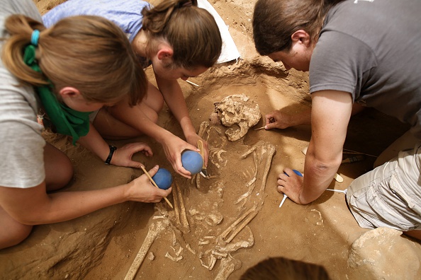 -Une équipe d'archéologues étrangers extrait des squelettes sur le site de fouille du premier cimetière philistin jamais découvert dans la ville israélienne côtière méditerranéenne d'Ashkelon. La découverte du cimetière marque le "couronnement" de quelque trois décennies de fouilles dans la région, ont indiqué les organisateurs de l'expédition. Photo de MENAHEM KAHANA / AFP / Getty Images.