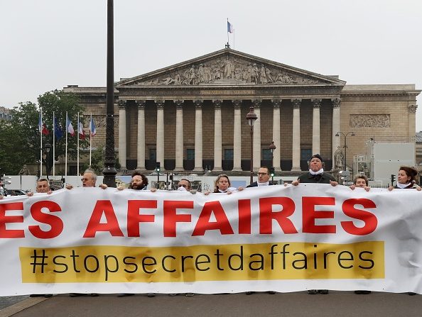 -Les gens tiennent une banderole sur laquelle il est écrit : « Plus de 550 000 citoyens déclarent qu'ils doivent cesser de faire secret », le 15 mai 2018, devant le Palais Bourbon à Paris, pour protester contre un projet de loi sur les secrets commerciaux. Photo de JACQUES DEMARTHON / AFP / Getty Images.