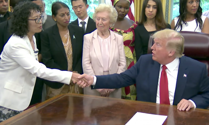 Le président Donald Trump serre la main de Zhang Yuhua, un pratiquant de Falun Gong qui a survécu à la persécution en Chine, à la Maison Blanche le 17 juillet 2019. (Capture d'écran / La Maison Blanche)