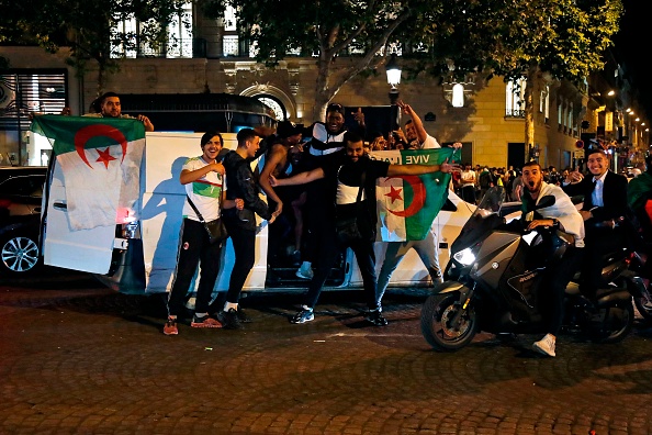 Des supporteurs célèbrent la victoire de l’équipe de football algérienne sur les Champs-Élysées le 19 juillet. Crédit : ZAKARIA ABDELKAFI/AFP/Getty Images.