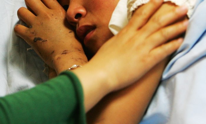 Une fille couchée dans un lit d'hôpital en Chine. (Guang Niu / Getty Images)
