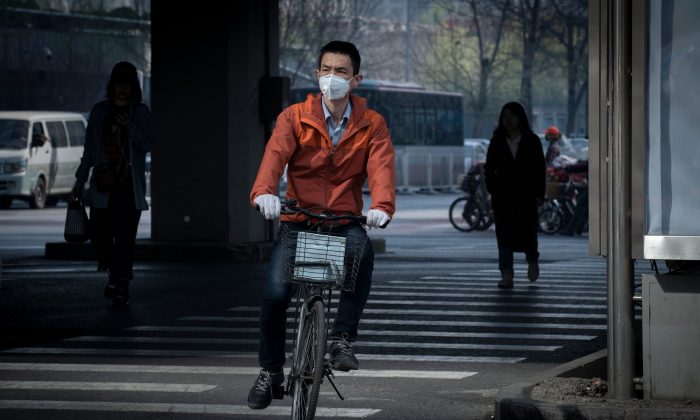 Un homme porte un masque pour réduire les effets de la pollution de l'air à Pékin, le 27 mars 2019. (Nicolas Asfouri/AFP/Getty Images)