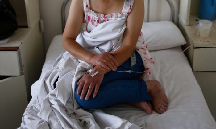 Une femme assise sur un lit d'hôpital en Chine. (AFP / AFP / Getty Images)