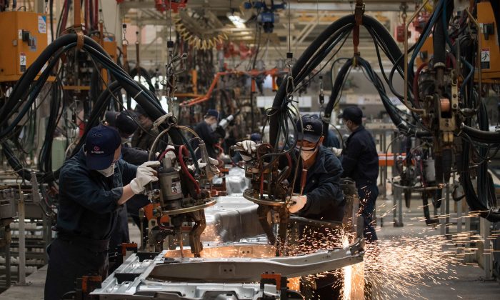 Les ouvriers soudent les pièces d’une voiture à la chaîne de montage de l’entreprise chinoise BAIC (Beijing Automotive Group Co) à Pékin, le 29 août 2018. (NICOLAS ASFOURI/AFP/Getty Images) 
