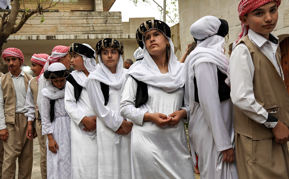 -Les Yézidis irakiens se rassemblent devant le temple de Lalish, dans une vallée près de la ville kurde de Dohuk, à environ 430 km au nord-ouest de la capitale Bagdad, le 16 avril 2019, lors d'une cérémonie commémorent l'arrivée de la lumière dans le monde lors des célébrations. Photo par SAFIN HAMED / AFP / Getty Images.