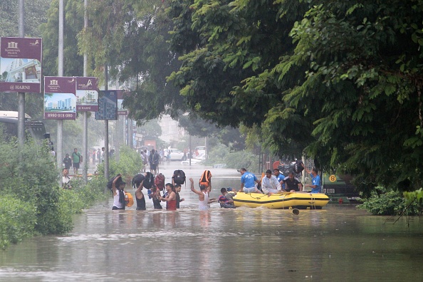 -Des personnes déferlent dans les eaux de crue pour embarquer dans un bateau de sauvetage de l'État du Gujarat, à Vadodara, à environ 110 km d'Ahmedabad le 1er août 2019. La ville de Vadodara, a été inondée à la suite de très fortes pluies le 31 juillet, par l’eau provenant du barrage d’Ajwa et de la rivière Vishwamitri. Photo de STR / AFP / Getty Images.