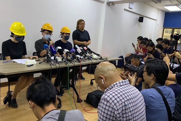 -Trois jeunes masqués du récent mouvement antigouvernemental en cours à Hong Kong tiennent une conférence de presse pour lire une liste de revendications et condamner les dirigeants pro-pékinois de la ville, à Hong Kong le 6 août 2019. Photo de Vanessa YUNG / AFP / Getty Images.