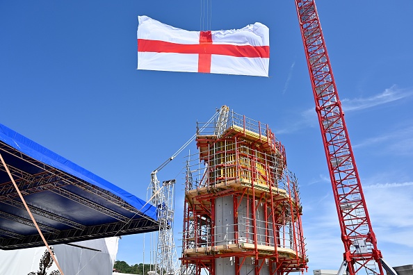 -Le drapeau de la croix de Saint-Georges, également appelé drapeau de la République de Gênes, flotte au vent sur le premier pylône du nouveau pont lors du premier anniversaire de la chute du pont de Morandi, à Gênes, le 14 août 2019. Photo by Alberto PIZZOLI / AFP / Getty Images.