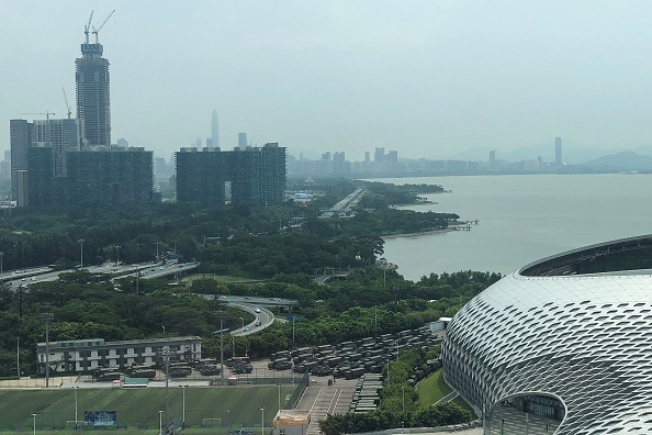 -Des camions et des véhicules blindés de transport de troupes sont vus à l'extérieur du stade de la baie de Shenzhen, à la frontière de Hong Kong, dans la province du Guangdong, dans le sud de la Chine, le 15 août 2019. Des milliers de militaires chinois ont organisé des exercices dans un stade situé dans le sud de la Chine ce matin, suscitant la crainte d'une intervention militaire à Hong Kong, qui connaît depuis des semaines de troubles civils. Photo de STR / AFP / Getty Images.