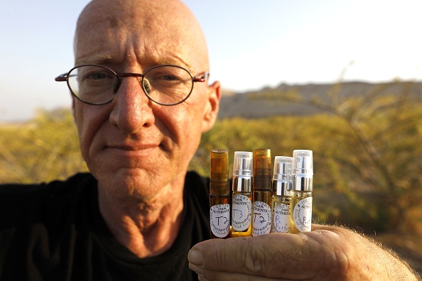 -Guy Erlich, agriculteur israélien, montre des ampoules d'huile parfumée extraites de plantes et d'arbres dans une ferme située sur une petite colline près de la colonie d'Almog, en Cisjordanie, le 28 mai 2019. Photo de MENAHEM KAHANA / AFP / Getty Images.