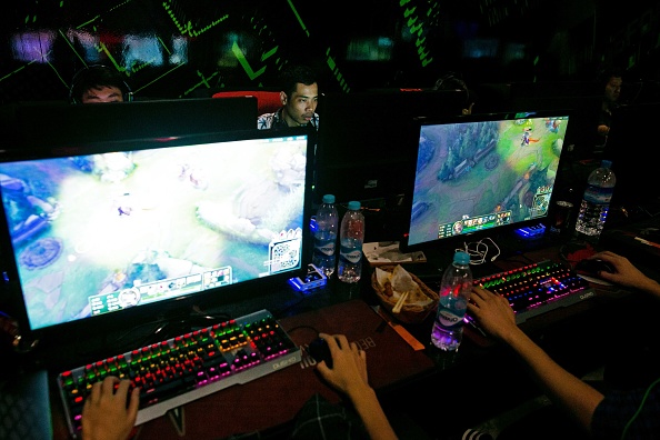 -Cette photo prise le 22 août 2019 montre le joueur professionnel de sports électroniques Myint Myat Zaw (à l’arrière-R), également connu sous le nom de "Insane", jouant à Dota 2 dans un magasin de sports électroniques à Yangon. Photo SAI AUNG MAIN / AFP / Getty Images.