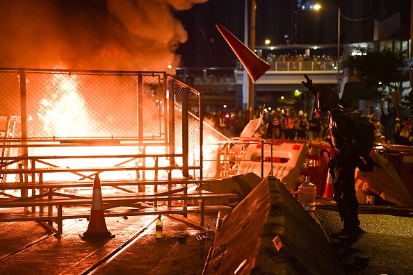 -Un manifestant jette un cône de rue dans une barricade qu'ils ont incendiée dans le district de Wan Chai à Hong Kong le 31 août 2019. Photo par Lillian SUWANRUMPHA / AFP / Getty Images.