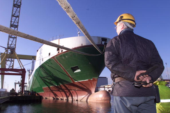 -Un ouvrier regarde le dernier navire construit par le chantier naval de Belfast, lors d'une cérémonie le 17 janvier 2003 à Belfast, en Irlande du Nord. La forte baisse du commerce au cours des dernières années a entraîné la perte de milliers de travailleurs. Le plus célèbre des bateaux construit sur ce chantier était le Titanic, qui avait été lancé du chantier le 31 mai 1911. Photo Getty Images.