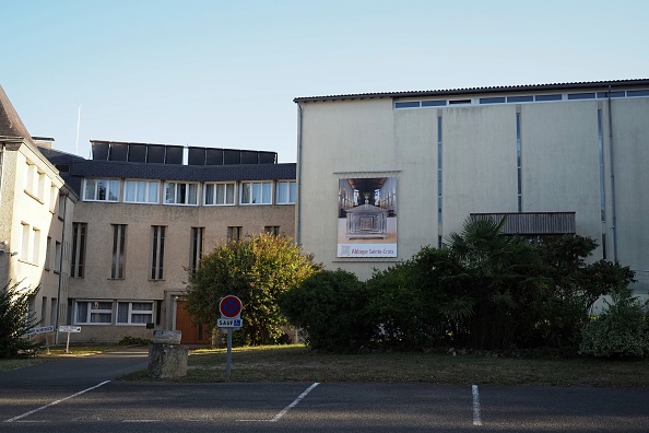 -Une photo prise le 19 septembre 2019 montre une pancarte sur un bâtiment de l'abbaye Sainte-Croix à Saint-Benoit, près de Poitiers, dans l'ouest de la France. À l’abbaye, des molécules à effets inconnus auraient été testées sur au moins 350 patients atteints de la maladie de Parkinson ou d’Alzheimer. Photo de GUILLAUME SOUVANT / AFP / Getty Images.