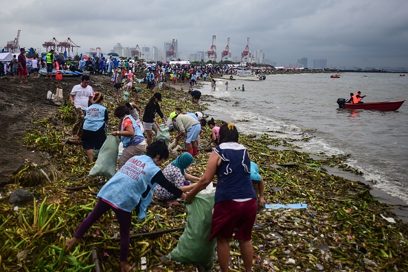 Des bénévoles ramassent des ordures alors qu'ils participent à la 34e Journée de nettoyage de la planète ce 21 septembre à Manille. (MARIA TAN/AFP/Getty Images)