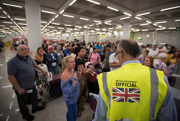 -Un responsable du gouvernement britannique s'entretient avec des passagers du groupe de voyages britannique Thomas Cook à l'aéroport Son Sant Joan de Palma de Majorque le 23 septembre 2019. 
Photo de JAIME REINA / AFP / Getty Images.
