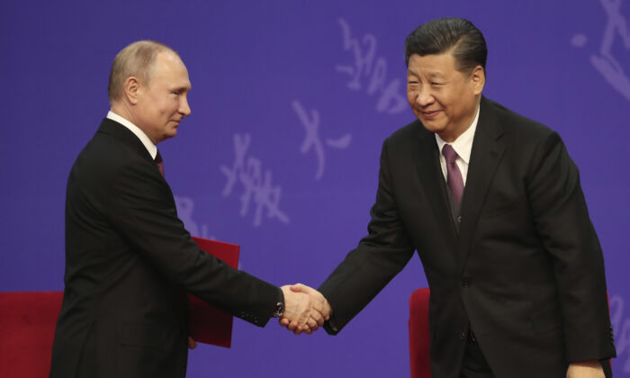 Le président russe Vladimir Poutine serre la main du dirigeant chinois Xi Jinping lors d’une cérémonie à l'Université Tsinghua à Pékin, le 26 avril 2019. (Kenzaburo Fukuhara - Pool/Getty Images)