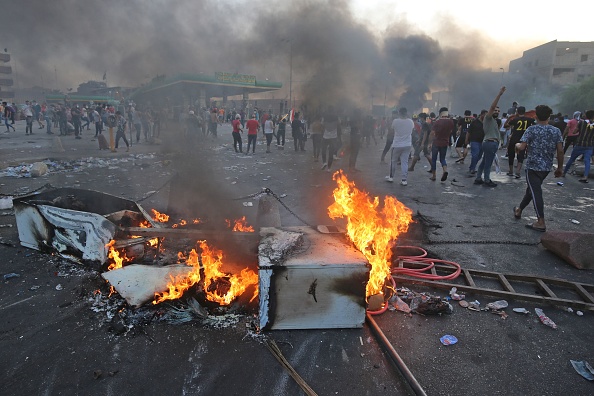 Des manifestants irakiens brûlent des objets pour bloquer la route lors de manifestations contre la corruption de l'État, les services publics défaillants et le chômage, sur la place Tayeran Square dans la capitale irakienne, Bagdad, le 3 octobre 2019. (Photo :  AHMAD AL-RUBAYE/AFP via Getty Images)